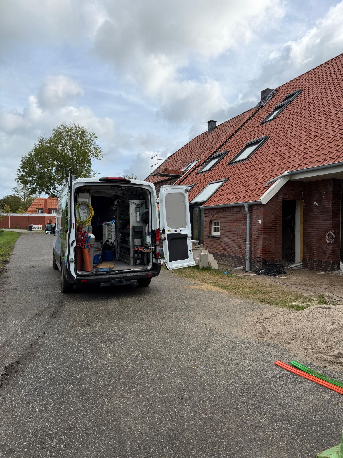 Servicewagen der DiViss GmbH – Heizung & Klima vor einem Neubau-Mehrfamilienhaus im Ammerland